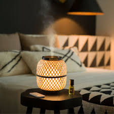 Difusor Estéban de bambú decorando un salón de estilo minimalista, con luz tenue y armonía visual.