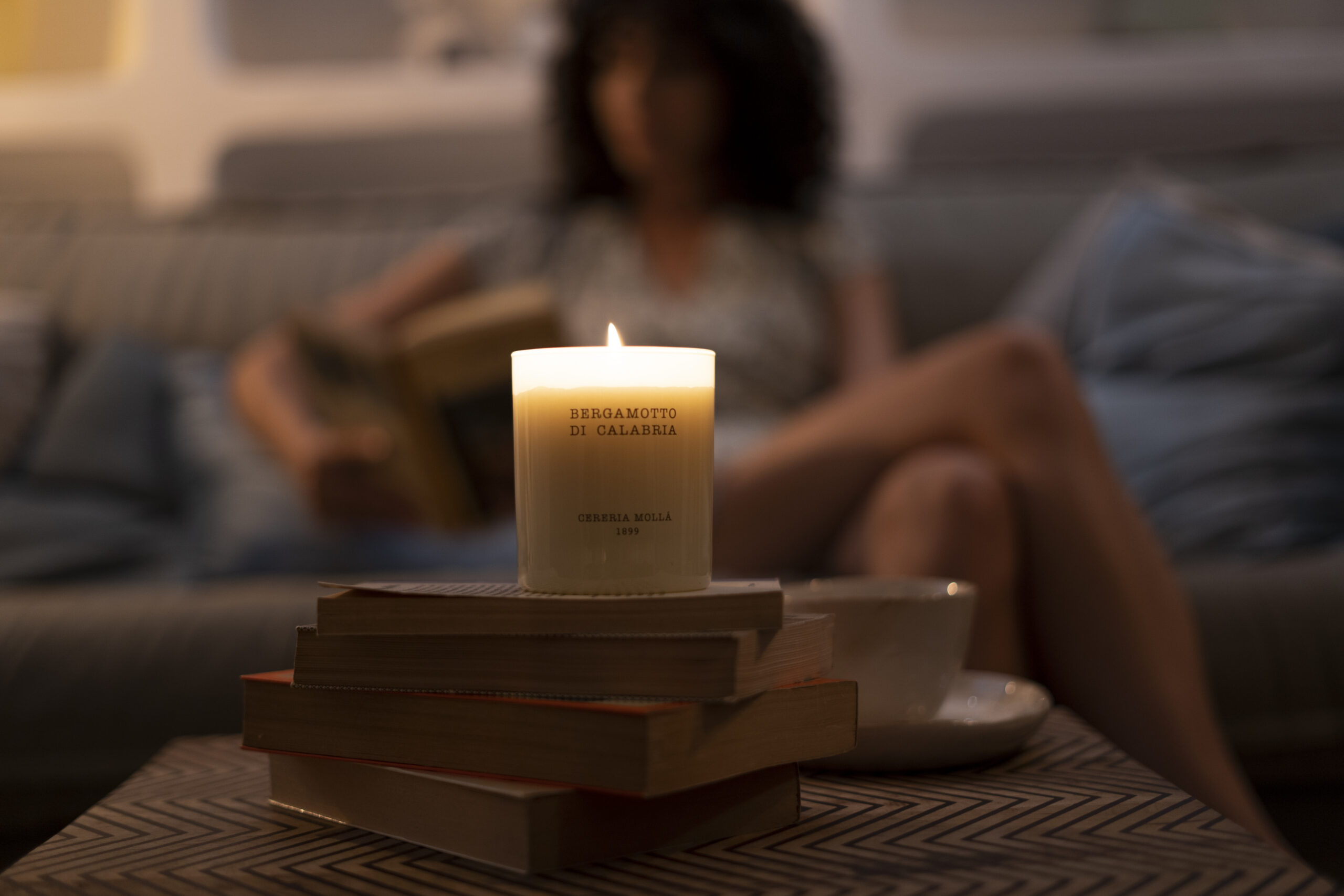 Vela encendida de Cereria Mollá en un ambiente de calma junto a libros