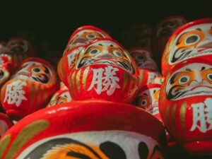 Daruma japonés rojo, símbolo tradicional de perseverancia y propósito, utilizado para fijar metas y representar la filosofía de levantarse tras cada caída.